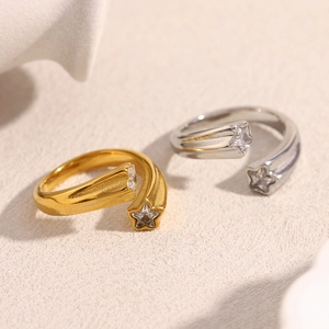 Detail of gold and silver open rings with star-shaped zircon stones on a stone base