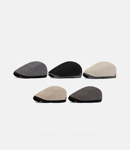 Detail view of five different British style newsboy hats in various colors and fabric textures