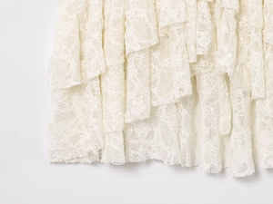 Vue détaillée de la dentelle florale blanche multicouche sur un chemisier élégant