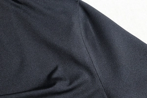 Close-up of the black elastic knit fabric texture and durable stitching on the dress