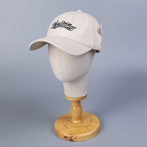 Beige cotton baseball cap with black Keelucky embroidery on a display mannequin stand