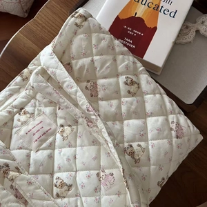 Close-up of quilted cotton tote bag featuring vintage teddy bear and floral patterns