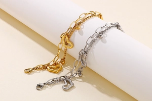 Détail de bracelets double couche en acier inoxydable avec cœurs à texture lave et perles