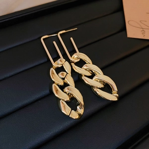 Macro shot of gold geometric link earrings with high polish finish on black display