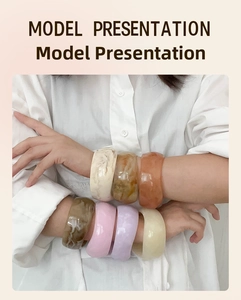 Detail showing stacked colorful chunky resin bangles with marble texture on model wrist