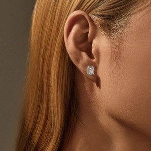 Elegant D-color emerald-cut moissanite silver stud earrings worn on a model's ear