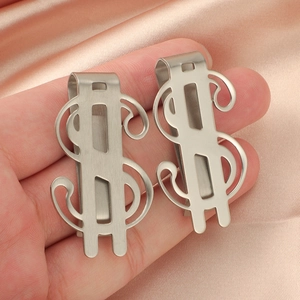 Macro view of dollar sign money clips in brushed stainless steel held over pink satin