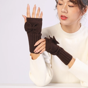 Detailed view of dark brown knit fingerless gloves with bow and ribbed cuff design