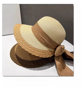 Close-up of woven straw sun hats featuring wave edges and large silk butterfly bows