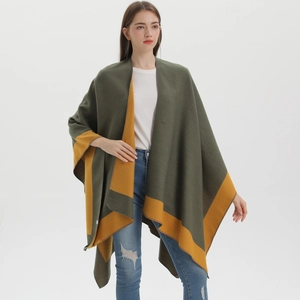 Detail of knit poncho in olive green and mustard yellow showing soft material texture