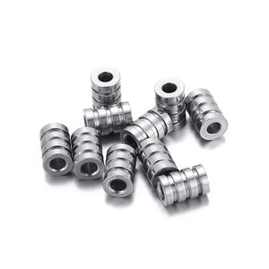 Pack of stainless steel grooved cylindrical hardware tubes on a white background