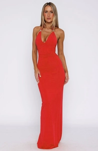 Detail of red floor-length dress featuring gold metal ring and v-neck pleat design
