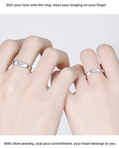 Detail of silver couple rings showing the interlocking heart design and fine inlay