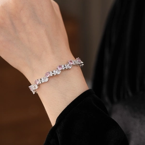 Macro shot of silver zigzag bracelet with pink and white zircon stones on woman's wrist