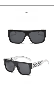 Detail view of fashion sunglasses with thick metallic chain arms and large black frames