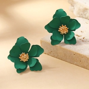 Elegant multi-layer green flower stud earrings with gold center on a stone display