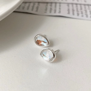 Macro view of teardrop iridescent stud earrings with silver metallic base setting