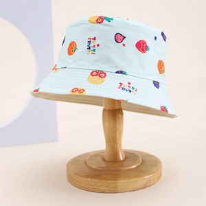Detail view of light blue children bucket hat with colorful fruit pattern on wooden stand