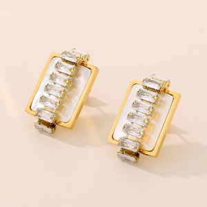 Detail of rectangular gold earrings with white inlay and sparkling cubic zirconia stones