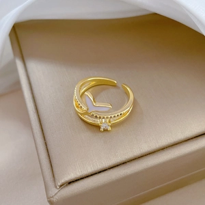 Macro view of gold mermaid tail ring with white enamel detail and sparkling zircon stone
