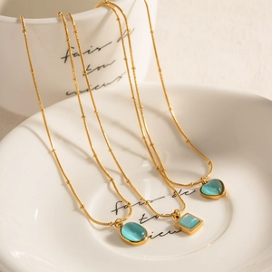 Set of three gold necklaces featuring oval, square, and heart-shaped teal cat eye stones