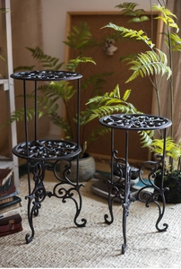 Détail de supports pour plantes en fonte noire mate avec motifs ajourés de style rétro