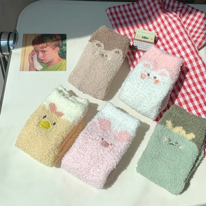 Detail of five pairs of thick coral fleece thermal socks with cute 3D cartoon animal faces