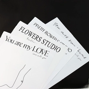 Close-up of waterproof matte floral gift paper with artistic typography on black backdrop