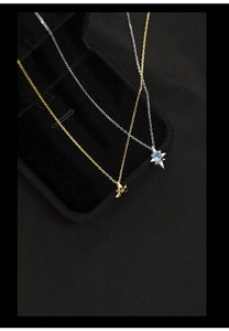 Detail view of star-shaped blue topaz necklace on black velvet luxury jewelry box