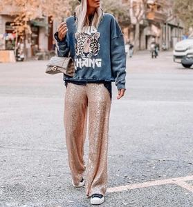 Detailed view of rose gold sequined wide-leg trousers paired with a street fashion style