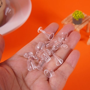 Set of 10 miniature clear dollhouse wine glasses and goblets held in hand for scale