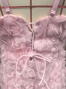 Détail du tissu rose à roses 3D et design corset à lacets sur une robe d'été