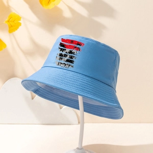 Détail d'un bob bleu avec imprimé plage tropicale au coucher du soleil et cocotiers