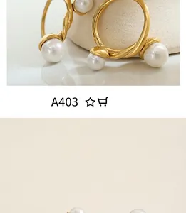 Detail of twisted gold metal hoop earrings with two symmetrical white pearls