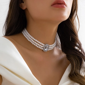 Close-up of triple-layer pearl choker necklace with a large crystal centerpiece