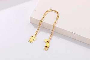 Détail d'un bracelet en acier titane doré avec pendentif fillette et fermoir mousqueton