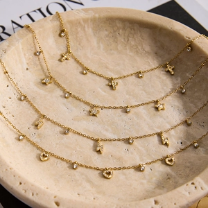 Close-up of gold titanium necklaces with cross, star, lightning, and heart pendants