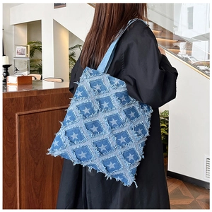 Detail of distressed denim tote bag featuring vintage star pattern and patchwork design