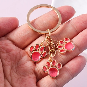 Cute golden cat paw keychain with pink enamel charms for backpacks and accessories