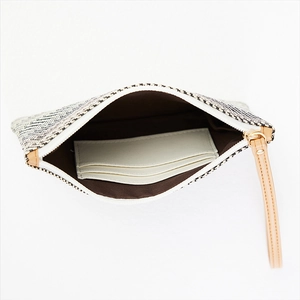 Detail view of woven clutch interior with three card slots and brown lining