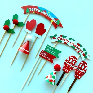Detail of various Merry Christmas cake toppers featuring paper bears, hats, and mittens