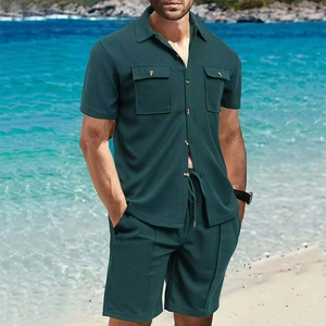 Detalle de conjunto gofre verde oscuro para hombre con polo y pantalones en la playa