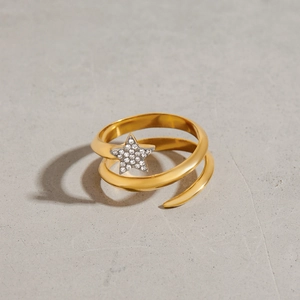 Detail view of a gold spiral ring featuring a sparkling star-shaped rhinestone pendant