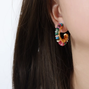 Vintage gold C-shape stud earrings with colorful natural stone beads on a model