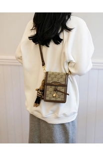 Detail of khaki bear monogram crossbody phone bag with cute teddy charm and adjustable strap