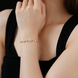 Gros plan d'un bracelet flocon en zircon doré porté par un mannequin sur fond sombre élégant