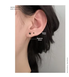 Primo piano di orecchini a lobo neri minimalisti in argento S999 nelle misure 1,5 mm e 3 mm