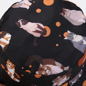 Detail of black reversible bucket hat with colorful cat prints and fabric texture