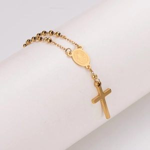 Minimalist gold beaded rosary bracelet featuring St. Benedict medal and cross charm