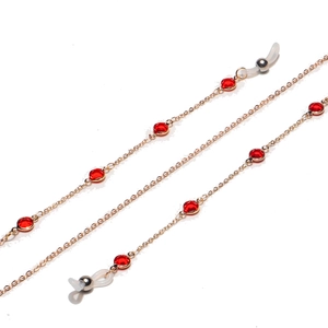 Macro shot of red crystal beads and golden metal chain for glasses or masks with rubber loops